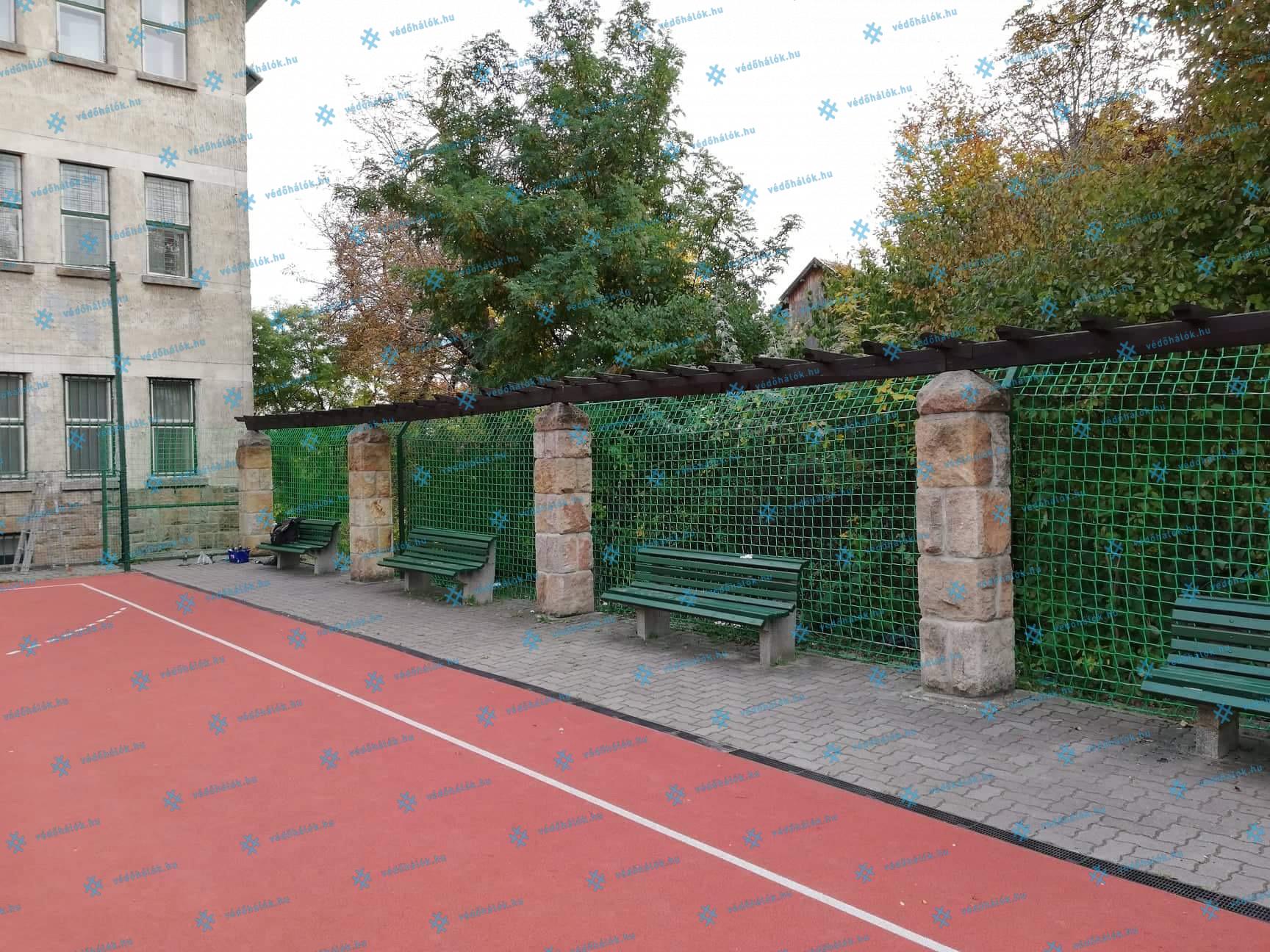 Labdafogó háló kültéri sportpálya mellett, budapesti gimnáziumban